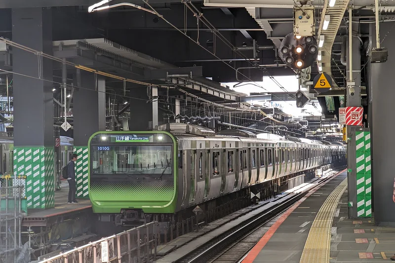 A Yamanote line train at Shibuya Station, directly below the tower